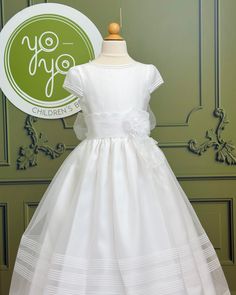 A traditional and classical first communion gown for girls, made with a lightweight white organza. It has beautiful pleats throughout the body and skirt. The flower appliqué is removable. It has buttons on the back for closure. True to size Dry clean 100% polyester Made in Spain Does not include crinoline Final Sale, no exchanges nor returns will be accepted First Communion Dress With Lace Bodice In Organza, Sleeveless Tulle First Communion Dress With Floral Applique, White Sleeveless First Communion Dress With Ruffles, Organza First Communion Dress With Ruffles, Organza Ball Gown For First Communion/pageant, Holy Communion Dresses, First Communion Dress, First Communion Dresses, Spanish Fashion