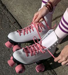 a person tying their roller skates with pink laces