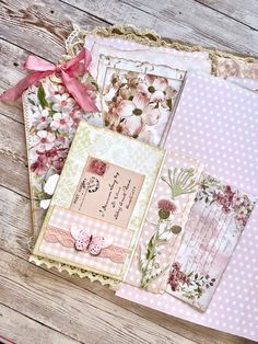 there are many different papers on the table with pink flowers and polka dotes around them