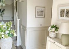 two vases filled with flowers sitting on top of a table next to a lamp