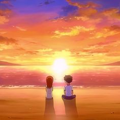 two people sitting on the beach watching the sunset