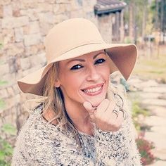 a woman wearing a hat posing for a photo