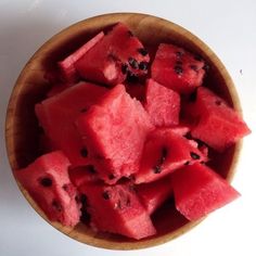 a wooden bowl filled with slices of watermelon