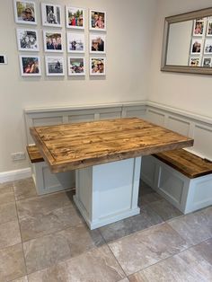 a kitchen table with two benches and pictures on the wall