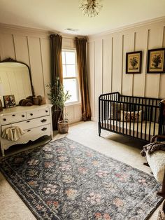 a baby's room with a crib, dresser and bed in it that has a rug on the floor