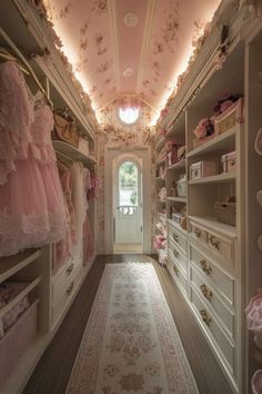 a walk in closet with lots of pink dresses on the shelves and drawers, along with an area rug