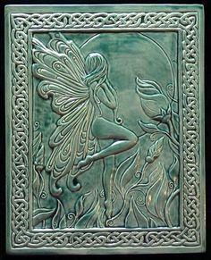 a green tile with a fairy and fish on it's side, in the shape of a frame