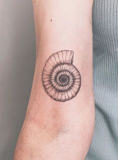 a tattoo on the arm of a person with a snail shell in it's center