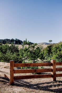 a wooden fence in the middle of a field