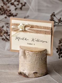 a place card holder made out of tree stumps and burlocked paper