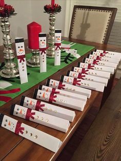 a table topped with lots of white boxes covered in snowmen and red candlesticks