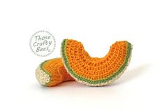 an orange crocheted stuffed animal laying on its side