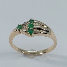 This stunning Emerald and Diamond Ring has been carefully crafted in warm 10K Yellow Gold , Authentic Emerald and Diamonds. Great for any occasion! Buy it for your-self or buy it for someone you love! Ring Weight and Stones Measurements: Ring weights 2.1 grams. Material: 10K Yellow Gold , Emeralds and Diamonds Emerald Measurements: 4 Emerald 2.25 mm (Color: Green) Diamonds: 2 Diamond 0.03 Total: 0.06 Ct Ring Size: 6 1/2 All of my jewelry is handmade from scratch and of high quality. Ring can be Green Three-stone Birthstone Ring In 14k Gold, Green Three Stone Birthstone Ring In 14k Gold, 14k Gold Green Rings With Accent Stones, Green 14k Gold Ring With Accent Stones, Green 14k Gold Rings With Accent Stones, Gold Emerald Three Stone Ring For Anniversary, 14k Gold Green Cluster Ring With Accent Stones, Green Diamond Ring With Accent Stones In 14k Gold, Green 14k Gold Cluster Ring With Accent Stones