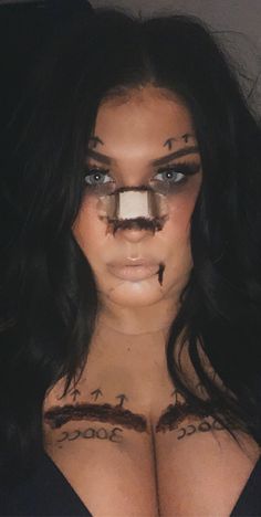 a woman with fake eyebrows and makeup has her face painted like a cross on it's chest