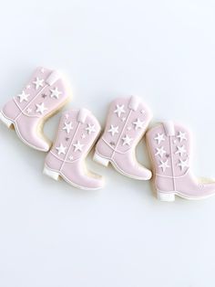 three decorated cookies in the shape of cowboy boots with stars on them, sitting next to each other