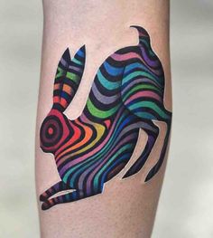 a colorful rabbit tattoo on the right thigh and calf's leg, with multi - colored stripes