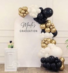 black, white and gold balloons are arranged in the shape of an arch for graduation