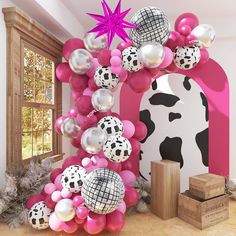 the balloon arch is decorated with pink, white and black balloons