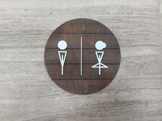 a wooden sign with two toilets on it's side and one in the middle