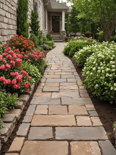 a stone walkway between two houses with flowers in the foreground