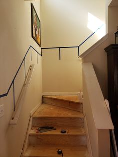 the stairs are made of wood and have blue handrails