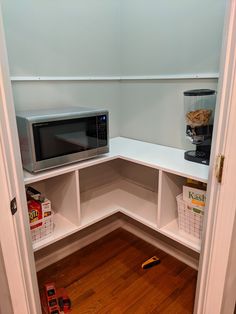 a microwave oven sitting on top of a white shelf