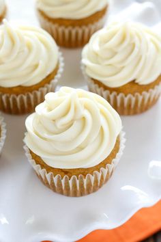 cupcakes with white frosting and nuts on a wooden table