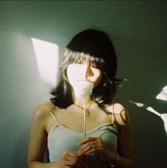 a woman standing in front of a wall with her shadow on the wall behind her