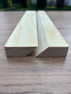 two pieces of wood sitting on top of a wooden table with one piece missing from it