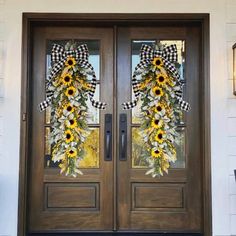 two sunflower wreaths on the front door of a house with black and white checkered ribbon