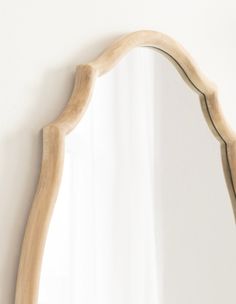 a wooden mirror mounted to the side of a wall