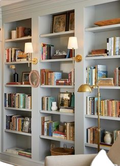 a living room filled with lots of books on top of book shelves next to a couch