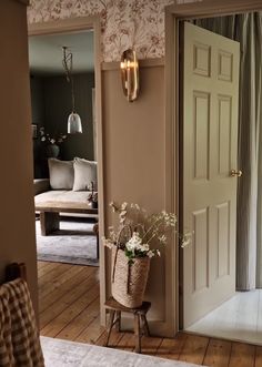 an open door in a room next to a vase with flowers