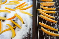 some orange peels are sitting on a rack in the snow and next to it is powdered sugar