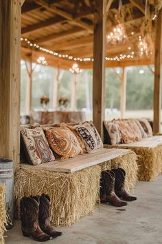 several hay bales with cowboy boots on them are lined up against the wall in this barn