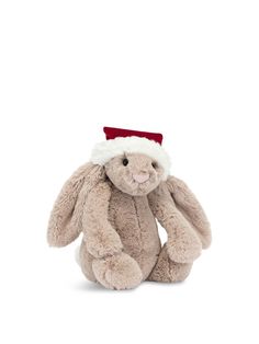 a stuffed rabbit with a santa hat on it's head and ears, sitting in front of a white background