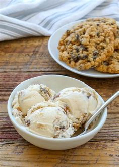 two white bowls filled with ice cream and cookies on top of a wooden table next to each other