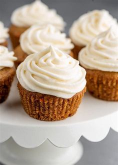 cupcakes with white frosting on a cake stand