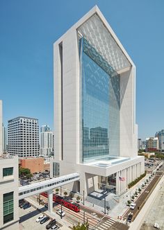 an aerial view of a modern building in the middle of a city with tall buildings