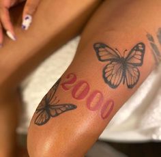 a close up of a person's arm with tattoos on it and butterflies around the wrist