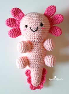 a pink crocheted stuffed animal laying on top of a table