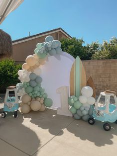 a blue and white car is parked in front of a balloon arch that reads 1