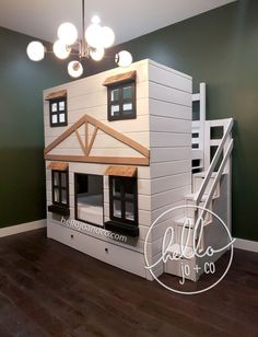 a doll house made out of cardboard with stairs and windows on the top floor in a green room