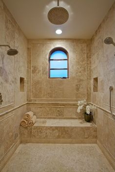 a very nice looking bathroom with some pretty flowers in the tub and shower head mounted on the wall