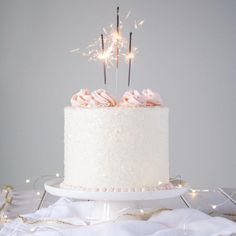 a white cake with sparklers on top