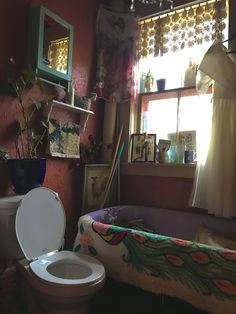 a bathroom with a white toilet sitting next to a bath tub in front of a window