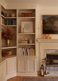 a living room filled with furniture and a fire place in front of a book shelf