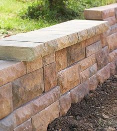 a close up of a brick wall with grass in the background