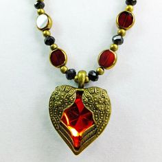 This beautiful deep red beaded necklace is OOAK. It measures 22 inches around. I used FLat red oval glass beads with a golden edge, black crystal beads, and round brass beads as spacers to give it a steampunk Victorian look. The red glass heart with brass wings pendant completes the vintage looking romantic theme.  The clasp is an easy to operate brass lobster claw clasp.  A perfect gift for a woman who loves rich sparkling red! I ship quickly. I accept Paypal and I will mail this necklace in a padded envelope in a gift box. Red Czech Glass Spiritual Jewelry, Red Faceted Beads Jewelry For Valentine's Day, Spiritual Red Jewelry With Black Beads, Red Beaded Spiritual Crystal Necklace, Red Spiritual Jewelry With Black Beads, Red Heart-shaped Beaded Necklace Gift, Red Heart-shaped Beaded Necklaces, Red Necklace With Black Beads As Gift, Red Spiritual Necklace With Heart Beads