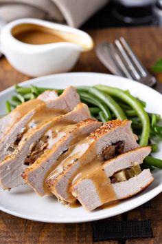 a white plate topped with meat covered in gravy